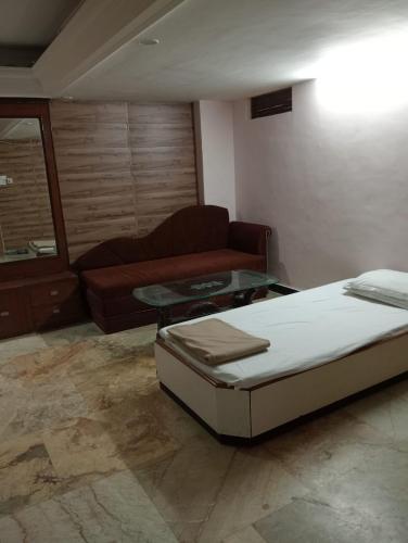 a living room with a bed and a couch at Hotel Sun Beam Near Gwalior Railway Station in Gwalior
