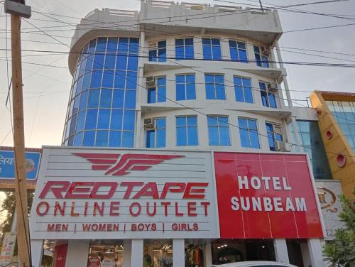 a tall building with a sign in front of it at Hotel Sun Beam Near Gwalior Railway Station in Gwalior