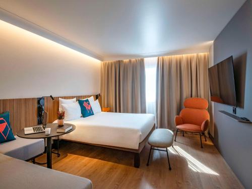 Habitación de hotel con cama grande y escritorio. en Novotel Nice Arenas Aeroport en Niza