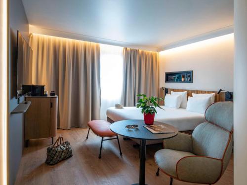 une chambre d'hôtel avec un lit et une table dans l'établissement Novotel Nice Arenas Aeroport, à Nice