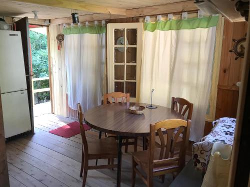 ein Esszimmer mit einem Tisch und Stühlen sowie einem Kühlschrank in der Unterkunft Isla Curubica in Tigre