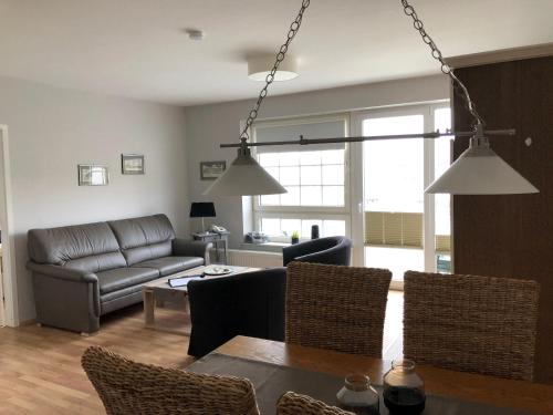 a living room with a couch and a table at Marbijes Appartementhaus in Cuxhaven