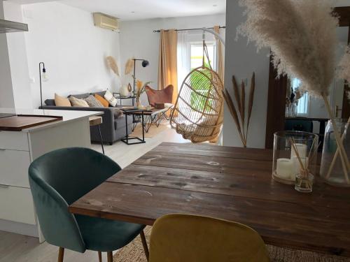 a kitchen and living room with a wooden table and chairs at Elegante apartamento 6-8pax AV Palmera 3D 2B in Seville