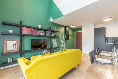 un salon avec un canapé jaune et une table dans l'établissement Bright 2-bedroom apartment w balcony and parking, à Lambersart