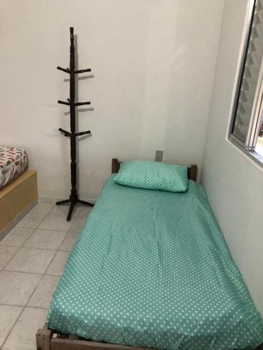 a small bedroom with a green bed in a room at Quartos em Alcobaça in Alcobaça