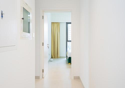 ドバイにあるTop Floor Apartment with Burj Khalifa Views and Full Downtown Views171BC-2の白い壁の廊下、ベッド1台が備わる客室です。