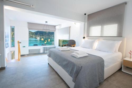 a bedroom with a large bed with two towels on it at Insieme Lefkada Maisonettes in Vlikhon