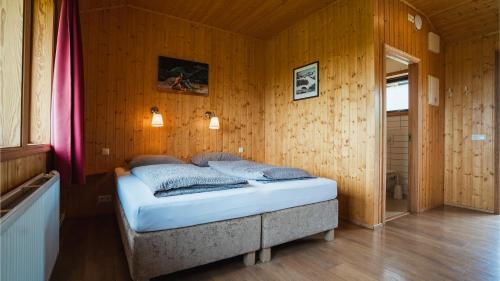 a bedroom with a bed in a wooden wall at Árnanes Country Hotel in Höfn