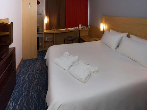Una habitación de hotel con una cama con toallas. en Ibis Yaroslavl Center, en Yaroslavl