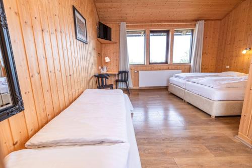 a room with two beds and a table in it at Árnanes Country Hotel in Höfn