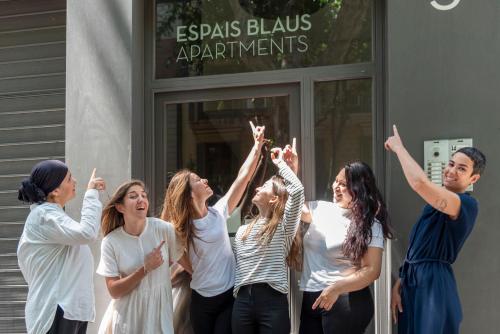 un grupo de mujeres de pie fuera de un edificio con las manos en el aire en Espais Blaus Apartments, en Barcelona