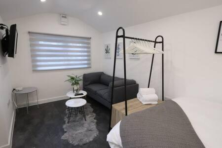 a living room with a bed and a couch at The Snug- Studio in Portishead with Parking in Portishead