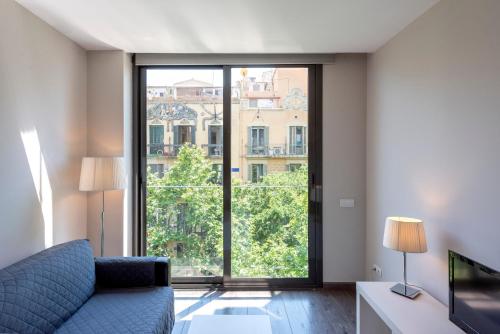 un salon avec un canapé et une grande fenêtre dans l'établissement Espais Blaus Apartments, à Barcelone