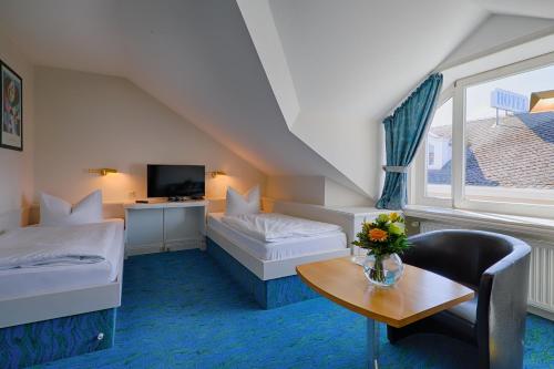 ヘリングスドルフにあるHotel Residenzのベッド2台とテーブルが備わるホテルルームです。