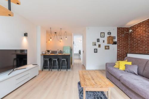 un salon avec un canapé et une table dans l'établissement Appartement lumineux avec rooftop et garage privé., à Lille