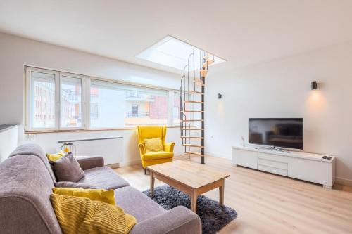 a living room with a couch and a tv at Appartement lumineux avec rooftop et garage privé. in Lille