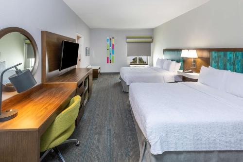 Hampton Inn & Suites Tulsa-Woodland Hills في تولسا: غرفة فندقية بسريرين وتلفزيون بشاشة مسطحة