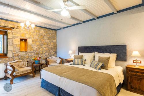 a bedroom with a large bed and a stone wall at Abeliona Retreat in Ambeliona