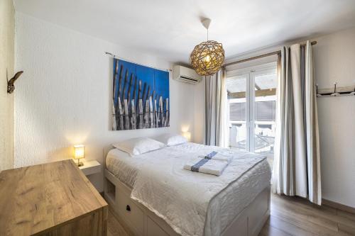 1 dormitorio con cama y ventana grande en La maison de Parrain - A proximité des plages, en Saint-Nazaire