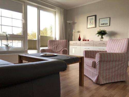 a living room with a couch and two chairs at Marbijes Appartementhaus in Cuxhaven