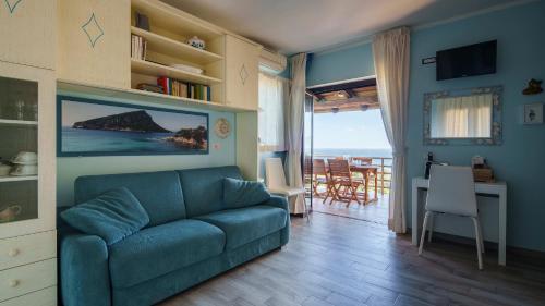 a living room with a blue couch and a table at Essenza Di Sardegna in Santa Marinella