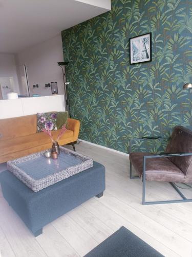 a living room with a couch and a table at De Lindehoeve Appartement de Deel in Vledder