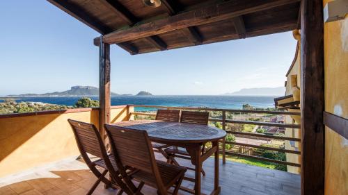 a table and chairs on a balcony with a view of the ocean at Essenza Di Sardegna in Santa Marinella