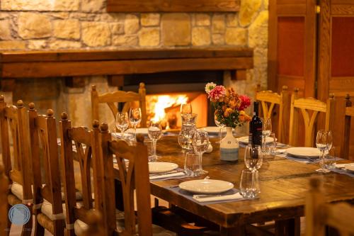 un restaurante con mesa de madera y chimenea en Abeliona Retreat, en Ambeliona