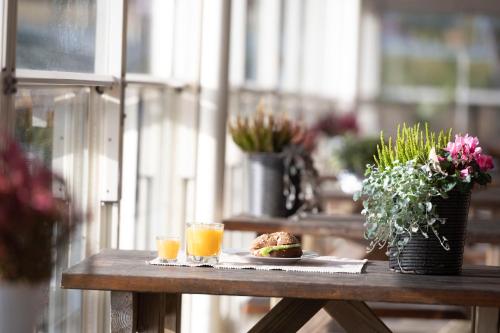 a table with a sandwich and two glasses of orange juice at Kapten Billes Restaurang och Logi in Norsholm