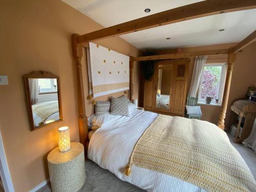 um quarto com uma cama grande e um espelho em Peak District Home from Home! em Grindleford Bridge