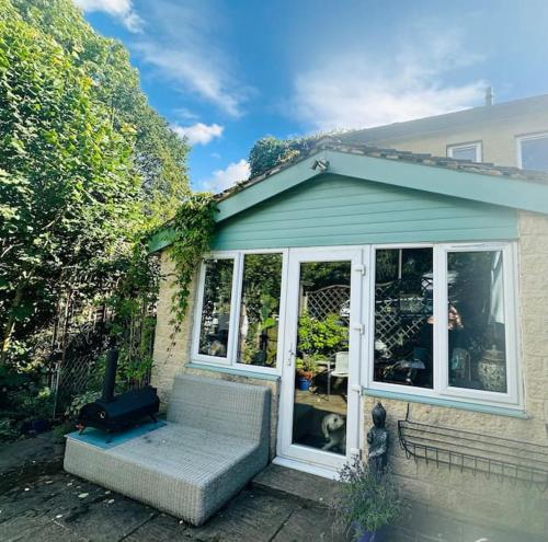 a house with a dog sitting on the porch at Peak District Home from Home! in Grindleford Bridge