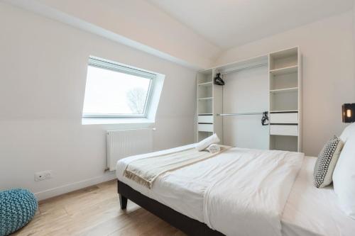 a white bedroom with a bed and a window at Renovated house with terrace 3 bedrooms in Wasquehal