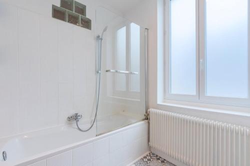 a white bathroom with a shower and a tub at Renovated house with terrace 3 bedrooms in Wasquehal