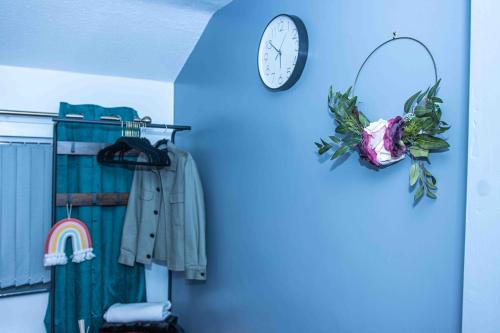 uma parede azul com um relógio e um armário em TD M-Gold Dudley Luxurious 3 Bedroom House - Sleeps 8 - Perfect for Leisure, Families, Business Long and Short Stay - Free Parking 
