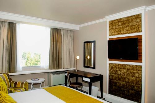 a hotel room with a bed and a desk at Riverside Sun in Vanderbijlpark