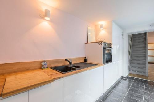 a kitchen with a sink and a refrigerator at Renovated house with terrace 3 bedrooms in Wasquehal