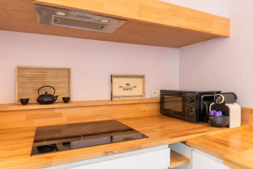 a kitchen with a microwave on a wooden counter at Renovated house with terrace 3 bedrooms in Wasquehal