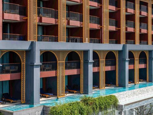 uma imagem de um edifício de apartamentos com piscina em Avista Grande Phuket Karon - MGallery em Praia de Karon