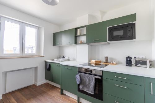 a kitchen with green cabinets and a microwave at Appartement L2 ARENA Gare Centre in Reims