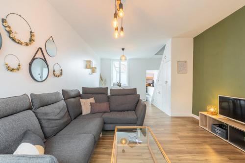 a living room with a couch and a tv at Renovated house with terrace 3 bedrooms in Wasquehal