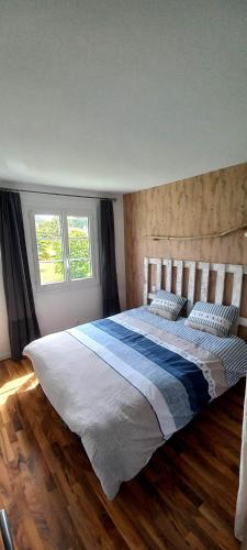 une chambre avec un grand lit avec deux oreillers dans l'établissement lacabaneagigi, à Chaillevette