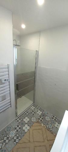 une douche avec une porte vitrée dans une salle de bain dans l'établissement lacabaneagigi, à Chaillevette