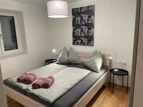 a bedroom with a bed with two pillows on it at Lake & Town Apartments Klagenfurt in Klagenfurt