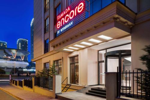 a store front of a hotel with a neon sign at Ramada Encore By Wyndham Istanbul Basin Express in Istanbul