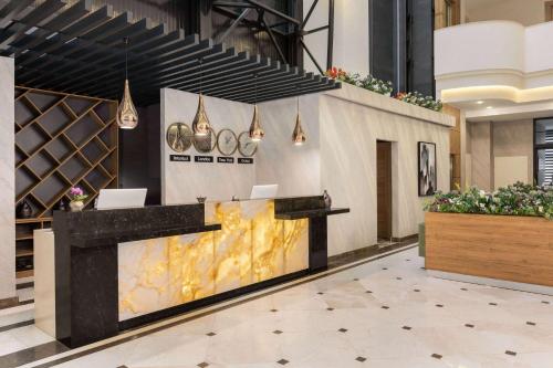 a lobby with a reception desk in a building at Ramada Encore By Wyndham Istanbul Basin Express in Istanbul