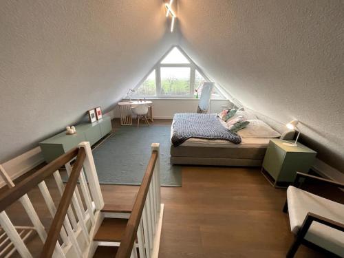 a attic room with a bed and a window at Steuerbord Nock mit Hund in Wangerland