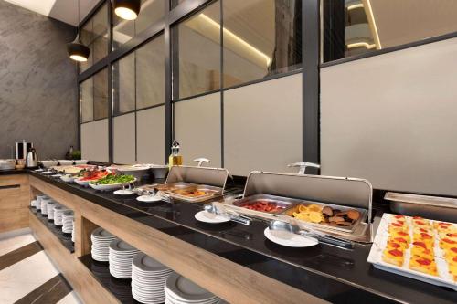 a buffet line with many different types of food at Ramada Encore By Wyndham Istanbul Basin Express in Istanbul