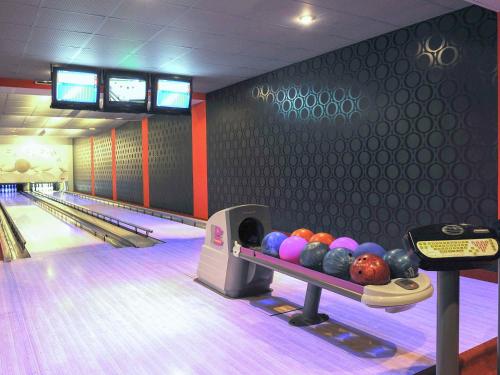 a bowling alley with a line of balls on the lanes at ibis Styles Warszawa West in Mory