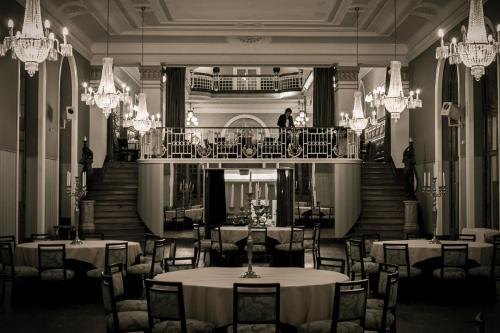 a black and white photo of a restaurant with tables and chandeliers at Curia Palace Hotel & Spa in Curia