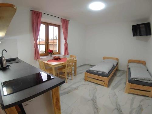 Cette chambre comprend une cuisine, une table et un lit. dans l'établissement Moravský Grunt Konírna, à Olomouc